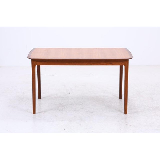 Vintage teak dining table by Lübke with softly rounded corners and a clean, period-typical design. The slender, tapered...
