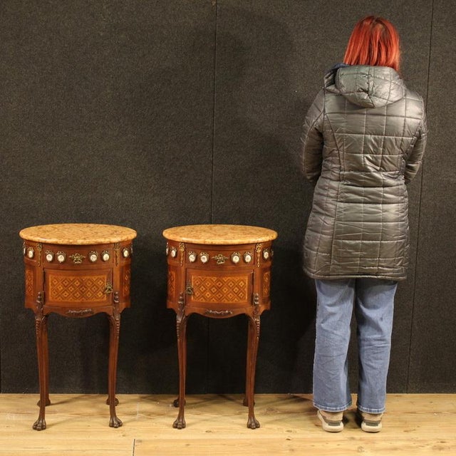 A pair of French bedside tables from the first half of the 20th century. Oval-shaped furniture with bronze ornaments,...