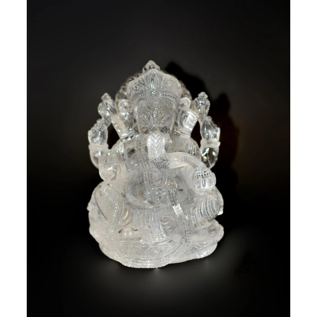 A remarkable 5 lb solid rock crystal quartz sculpture of Ganesha. Seated on a lotus throne and backed by a radiate...