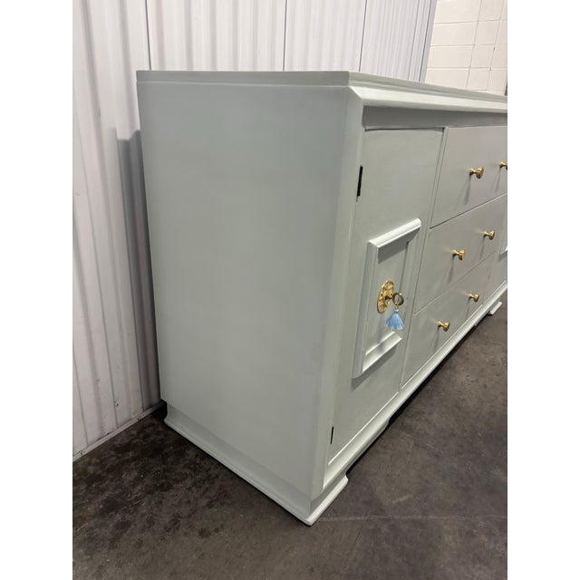 Offered is a vintage solid wood credenza. This piece features three dovetailed smooth gliding drawers, pair of cabinet...