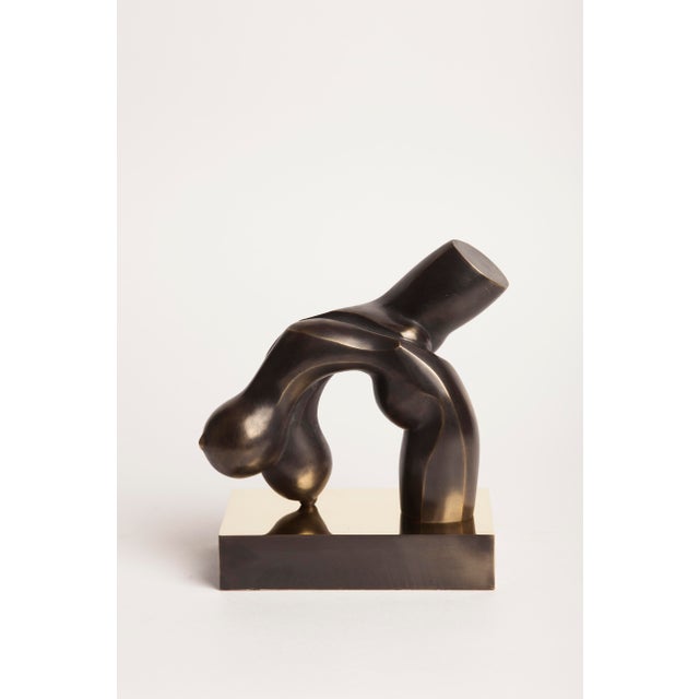 A contemporary figurative bronze of the female body, abstracted into a single arched, flowing form. The artist reduces the...