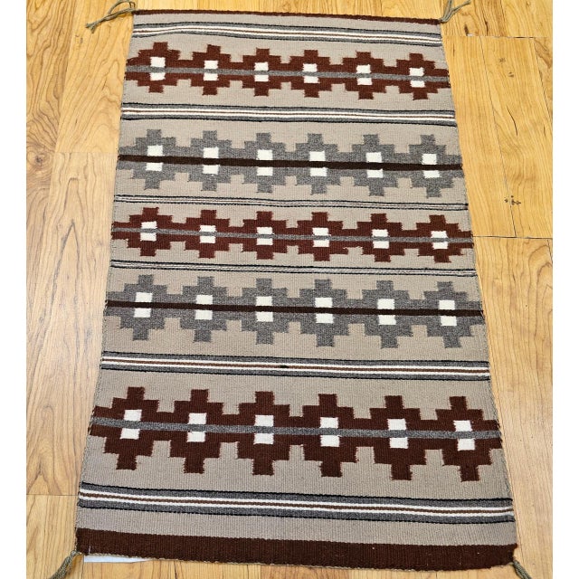 A beautifully woven vintage Navajo rug from the third quarter of the 20th century, this textile showcases a bold banded...