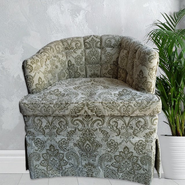 Vintage mid-century barrel back armchair with biscuit-tufted rounded backrest features ornate olive and cream damask...