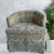 Vintage mid-century barrel back armchair with biscuit-tufted rounded backrest features ornate olive and cream damask...