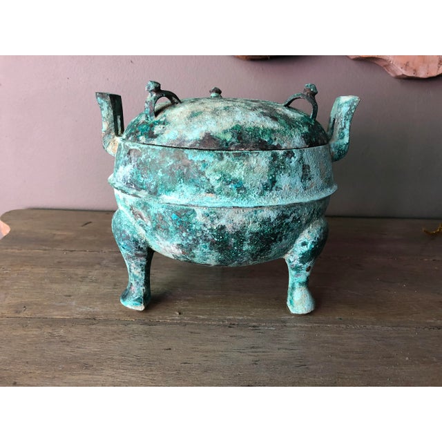 Covered bronze Ding covered tripod pot. Made during the Han Dynasty (206 BC-AD 220).