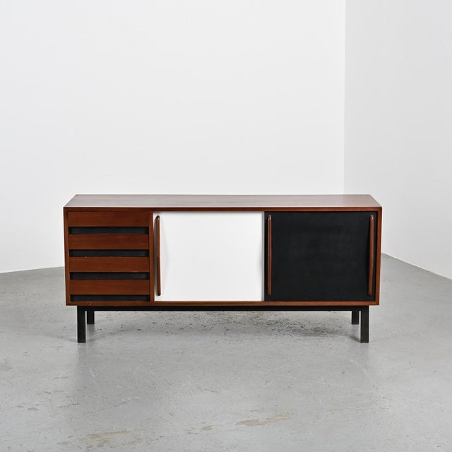 Sideboard, known as "Cansado," designed in 1957 by Charlotte Perriand. Mahogany veneer structure with two sliding doors in...
