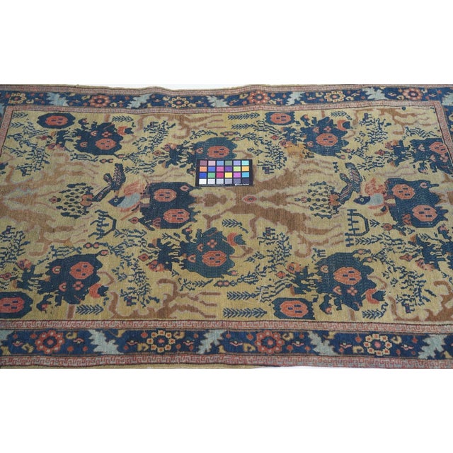 The straw field presents a version of the allover Mustafi design with navy bouquets and rough rose "leaves". "Faces" in...