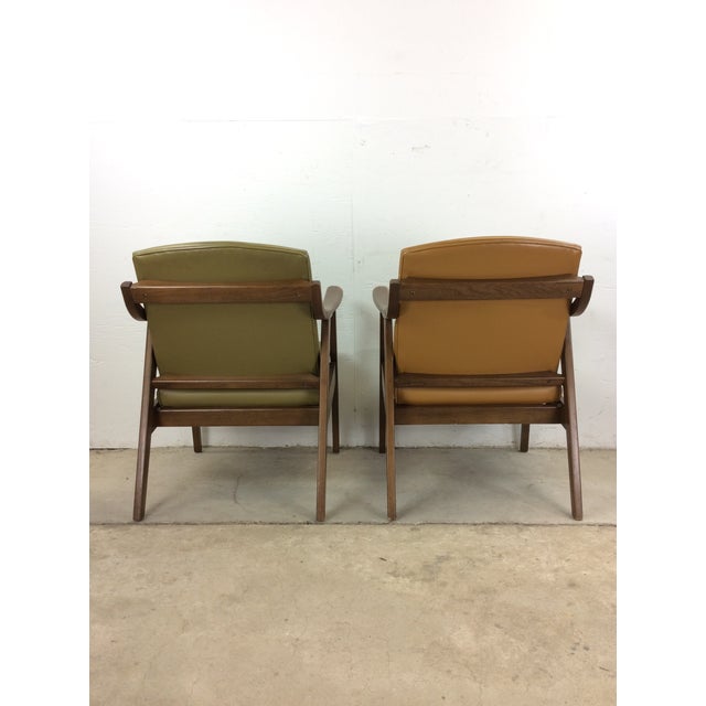 This mid century modern lounge chair features hardwood frames, original walnut finish, sculpted arm rests, tall tapered...