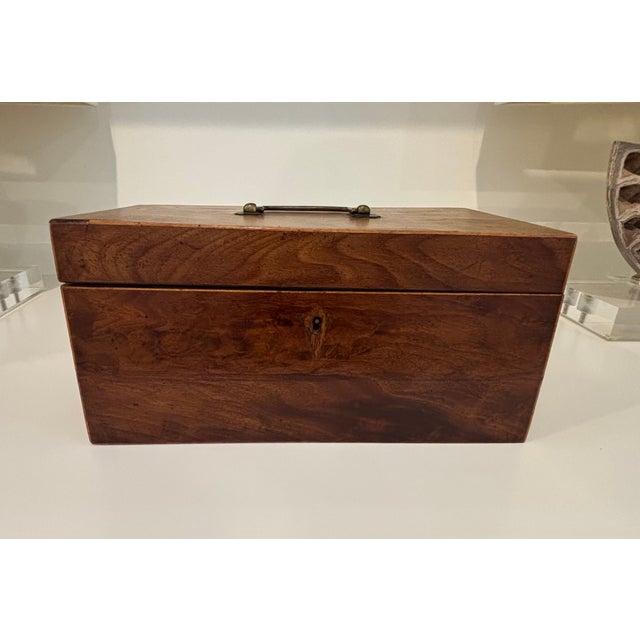 Elegant Georgian-period English tea caddy in rectangular form, fitted with an original brass bail handle. The caddy opens...