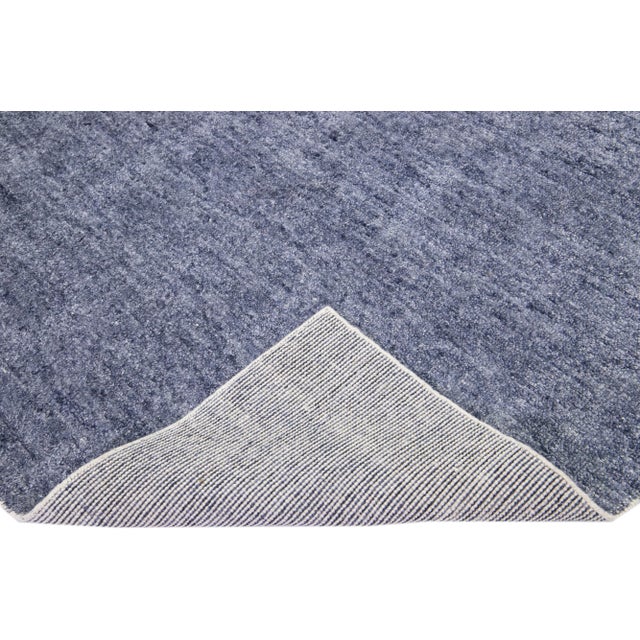 Beautiful Apadanas's handmade bamboo & silk Indian groove rug with a blue color field. This groove collection rug has an...
