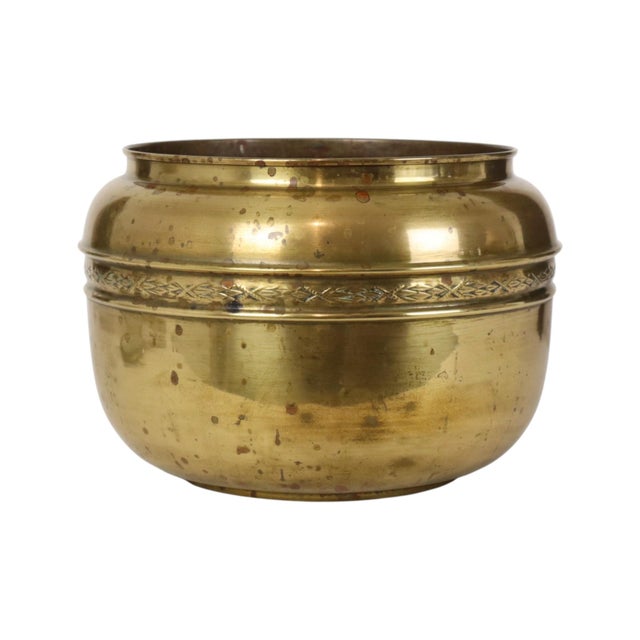 Large brass cache-pot—an elegant, rounded repoussé flower pot or jardinière featuring a ribbon pattern around the body....