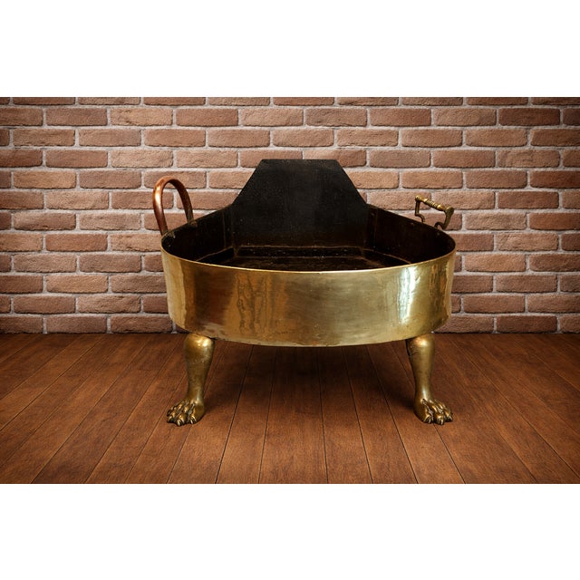 This particular piece, with its ornate clawed feet and substantial brass construction, suggests a decorative function,...