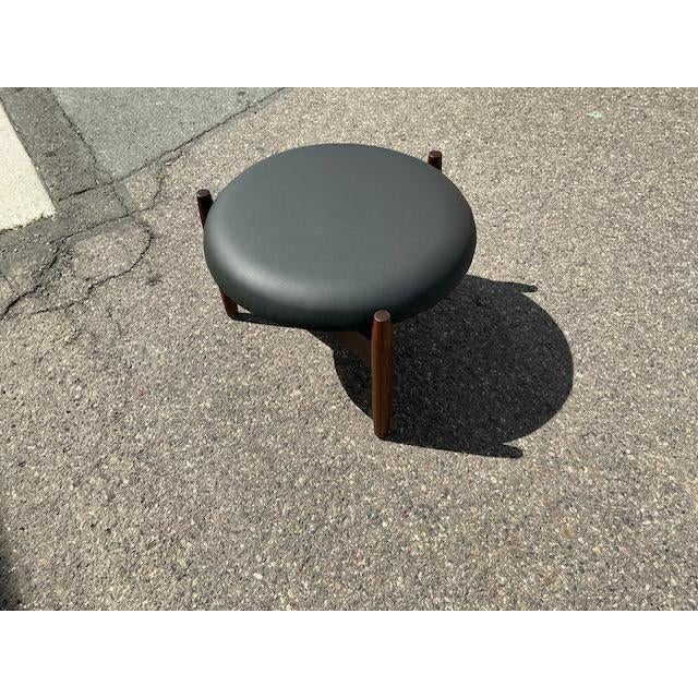 Mid century style walnut and black leather ottoman. Manner of Hugo Frandsen in the 1960s . Well made 3 legs, solid walnut.