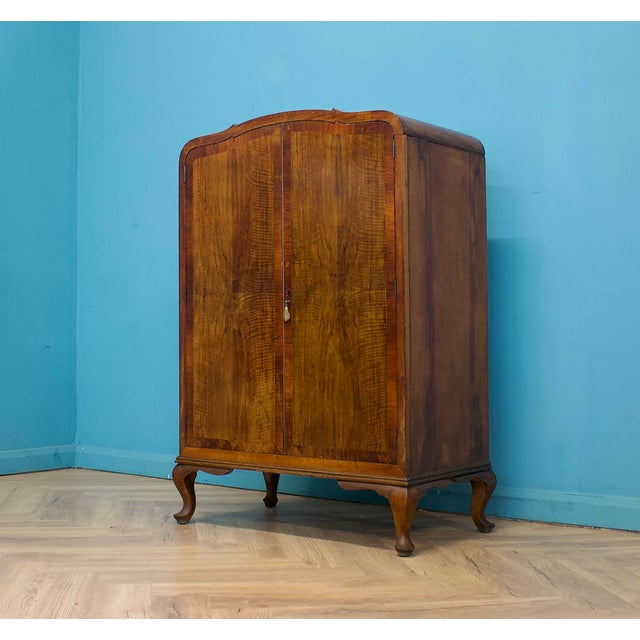 Compact walnut linen cabinet with a drawer over double doors. Inside are fixed shelves for practical storage. The drawer...