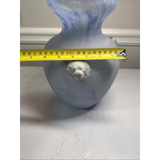 A mid-century modern Murano scavo glass vase from Italy, in a matte blue and mauve finish with two raised lion heads and a...