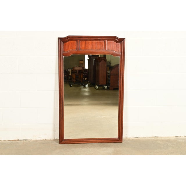 A gorgeous Mid-Century Modern Hollywood Regency Campaign style carved walnut framed wall mirror By Thomasville USA, 1977...