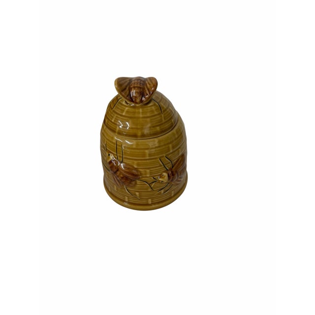 Vintage brown glazed honey jar decorated with honey bees in a textured background. Measures 4” diameter x 5” h.