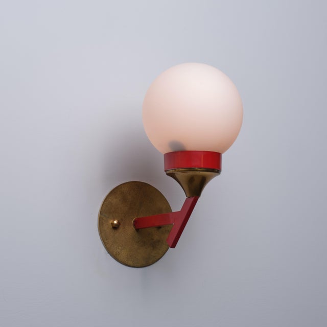 Italian wall sconce dating from the 1950s, characterized by a bold geometric composition and a distinctive contrast of...