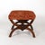 Carved walnut stool of curule form, the opposing X-frames centered to each end by fairly dignified and naturalistically...