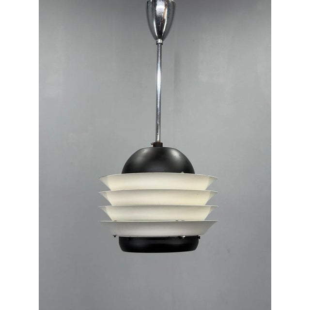 Original mid-century pendant lamp manufactured by lidokov in czechoslovakia in the 1970s. The sculptural tiered shade...