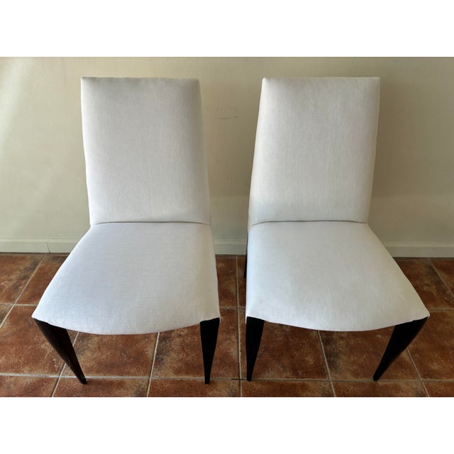This striking pair of contemporary dining chairs are made of ebony wood. They have been recently reupholstered in gorgeous...