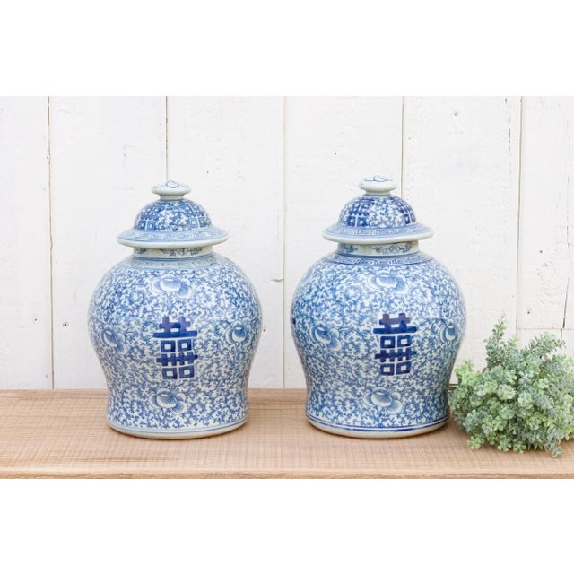 A pair of vintage blue-and-white ginger jars. Their colorful presence, with broad shoulders tapering to a graceful base...