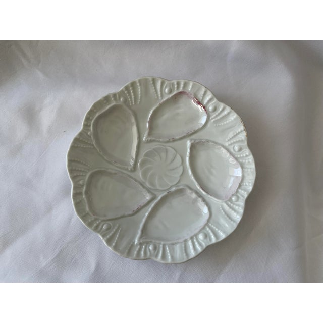 1890-1900 European porcelain oyster plate with 5 oyster wells and one dip well. This antique plate once had gold trim and...