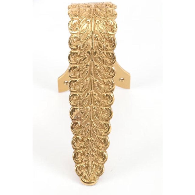 A pair of curved, solid brass drapery tiebacks from the "Empire" line created by the legendary Parisian firm, Houlès....