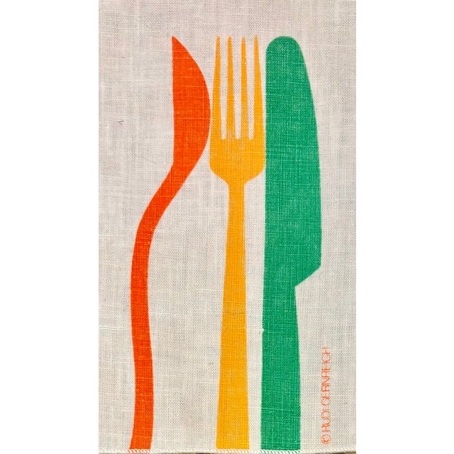 These pop art dinner napkins feature a bold, minimalist mid-century modern graphic of a flatware setting-an orange spoon...