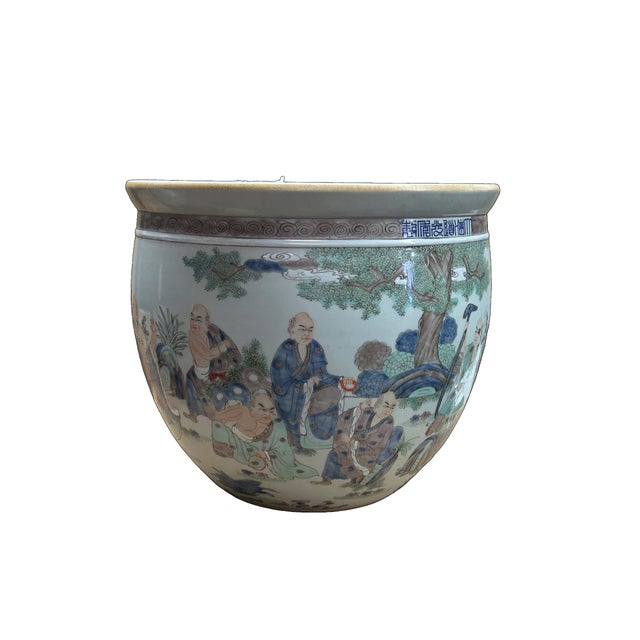 This large, famille rose porcelain fish bowl features an expansive narrative scene depicting the Eighteen Luohan (Arhats)...