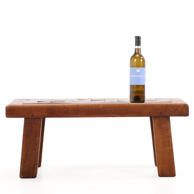 A striking French Brutalist coffee table dating to circa 1965, crafted from solid oak with a richly glazed ceramic tile...