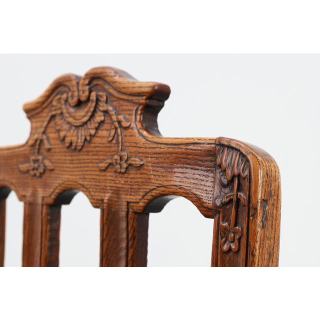 A graceful pair of carved oak side chairs from 18th‑century France, executed in the Régence style. Each chair features a...