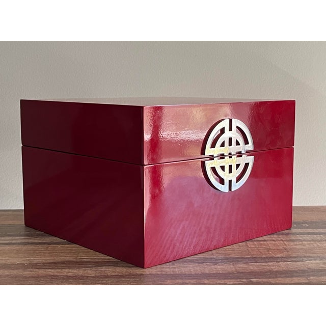 A vintage Asian inspired red lacquer box with silver tone accent and black lining.