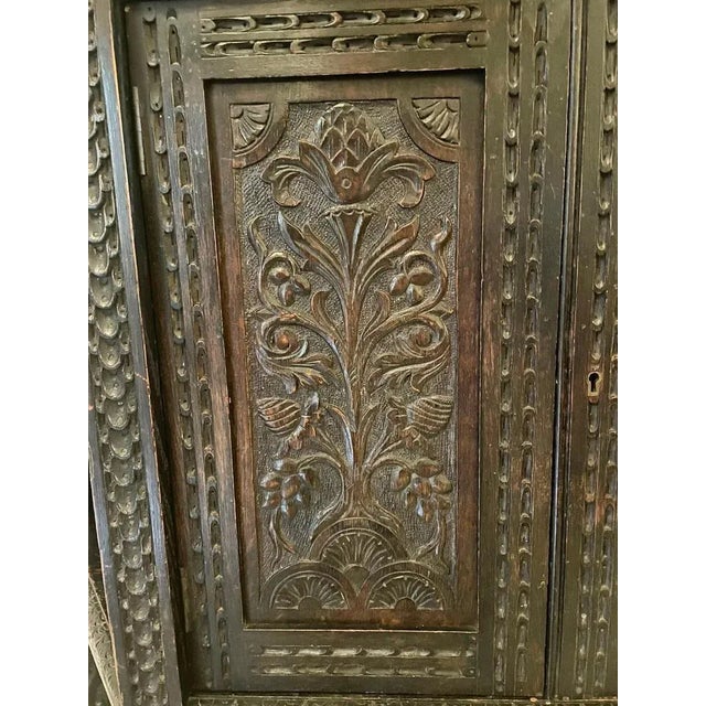 Large antique victorian carved oak side cabinet having a shaped carved cornice above a single door flanked by two panels...
