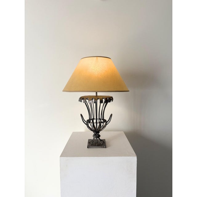 A striking fluted table lamp with twin handles and a caged metal design. The intricate hand made structure gives a sense...