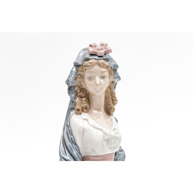 A graceful Lladró porcelain figurine of a young woman in 18th-century Spanish period dress, produced circa 1980 and marked...