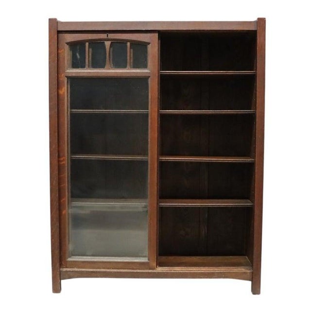 This antique Arts & Crafts Mission Oak bookcase, dating to approximately 1910, features a robust construction emblematic...