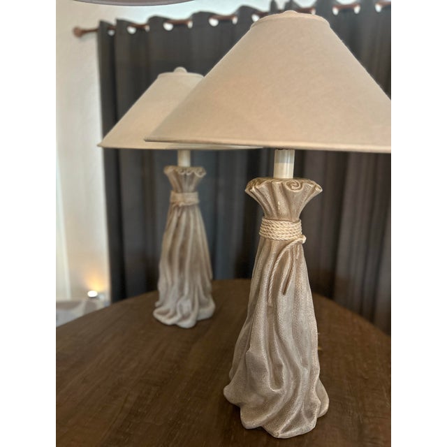 A Tall Pair of Sculptural “trompe l’oeil” Plaster Table Lamps by PIERI CREATIONS, dated 1995. This sophisticated design...