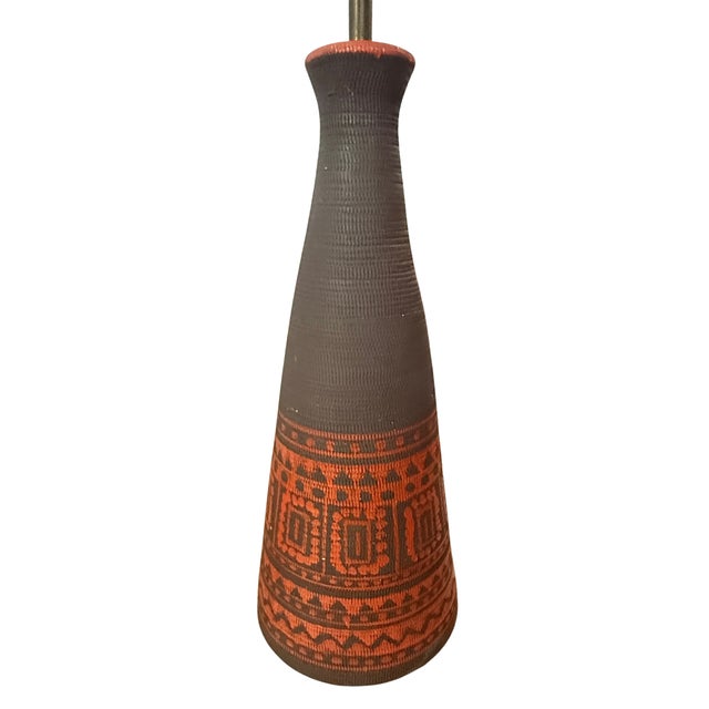 A striking pair of mid century pottery lamps featuring conical silhouettes, textured ceramic surfaces, and warm...