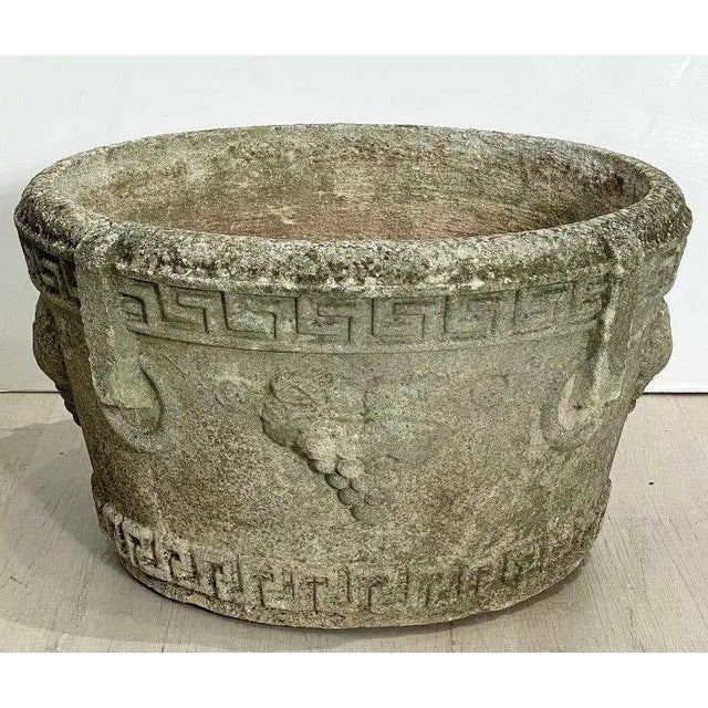 A fine English round garden urn or planter pot of composition stone, featuring a relief Greek Key design and grape...