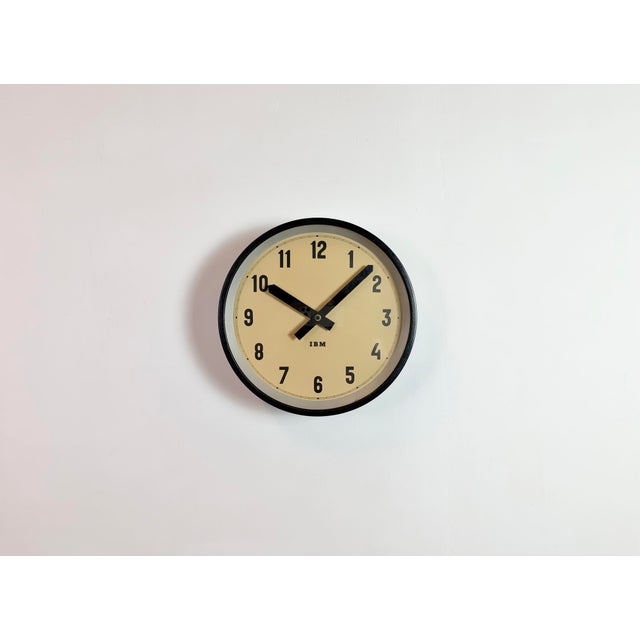 This wall clock was produced by IBM in USA during the 1950s. It features a black metal frame, iron dial, aluminium hands...