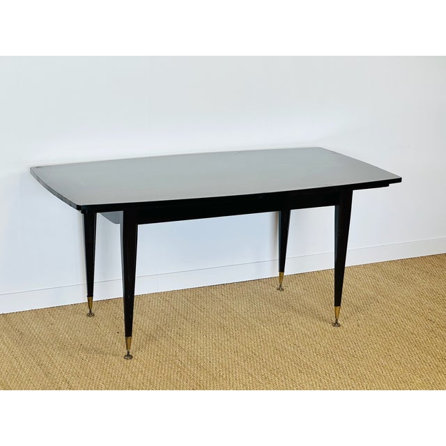 An elegant rectangular dining table dating from the 1940s-1950s, featuring a stunning Macassar veneer top with a rich,...