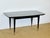 An elegant rectangular dining table dating from the 1940s-1950s, featuring a stunning Macassar veneer top with a rich,...