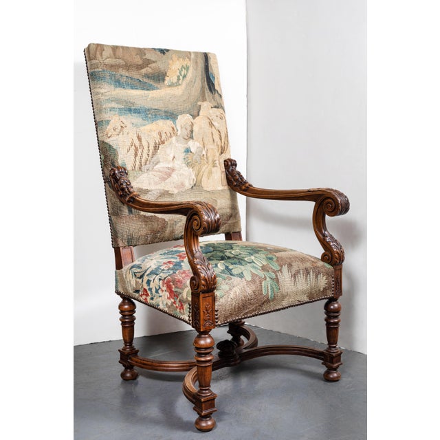 Elegantly carved, circa 1850, French armchair with scrolling, foliate embellished arm rests, and a sleek, X-form...