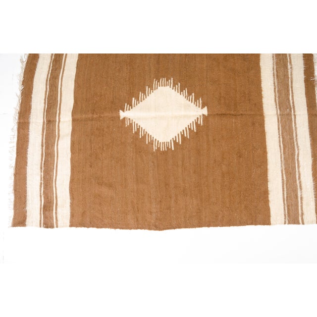 This is a vintage Turkish Oushak rug from the Mid 20th Century. The piece was hand-knotted.