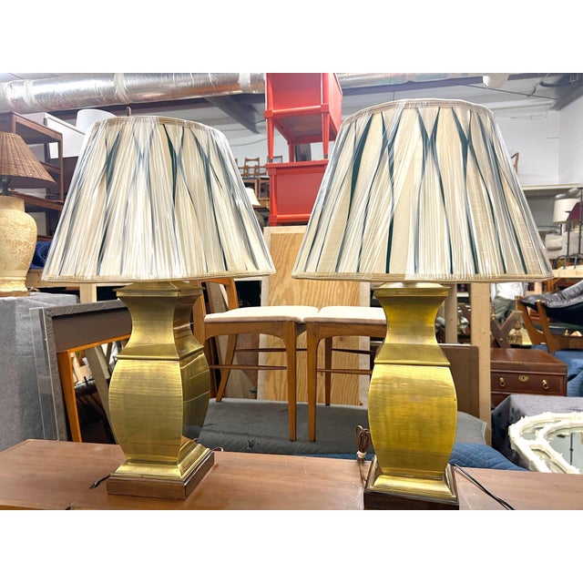 Pair of Brass Mid Century Asian Style Lamps A pair of Asian style mid century brass table lamps on a shaped wood base....