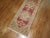 Mid-20th century red field Turkish runner with an all-over repetitive medallion design. Measures: 2'1” x 11'9”.