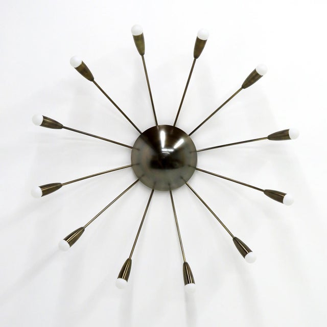 Elegant aged brass twelve light Aurora wall or ceiling light designed by Gallery L7, handcrafted and finished in Los...