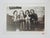 1950's vernacular snapshot photograph of a group of women sitting on a sofa. On the wall behind them is a large image of a...
