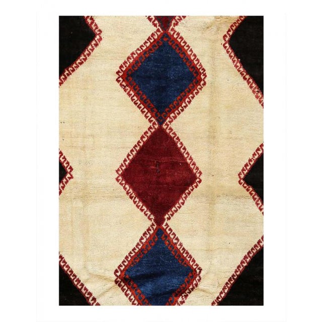 A ruggedly enchanting tale unfolds in the embrace of this hand-knotted wool vintage Persian Afshar rug. Imagine the cozy...